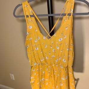 Yellow romper with daisy and crossback